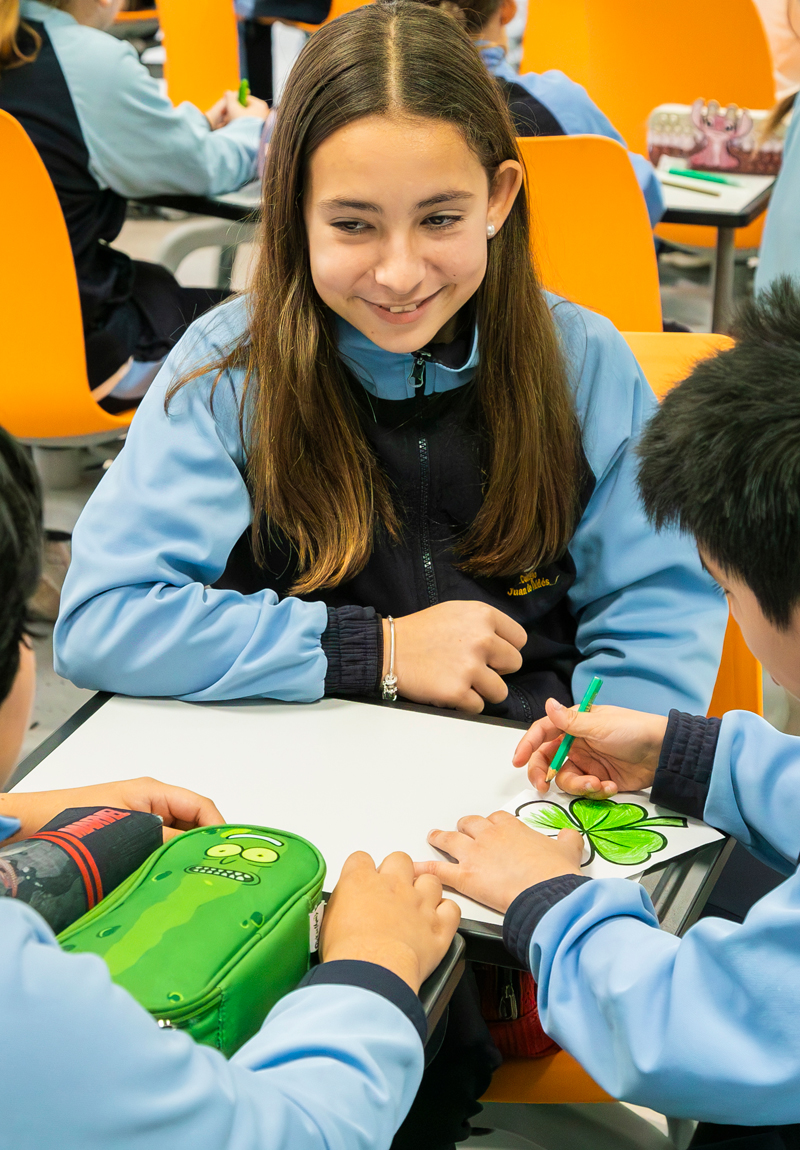Alumna leyendo a niños pequeños en Primaria